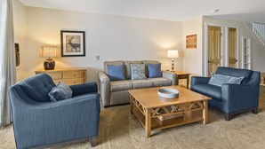 A living room with a sofa, two armchairs, a coffee table, and a lamp. - Lodge Condo 30 (Stowe)