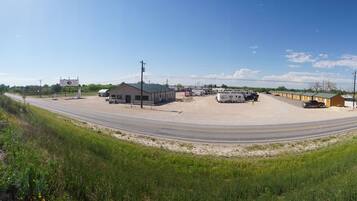 A rural roadside with a gas station, RV parking, and a small building.