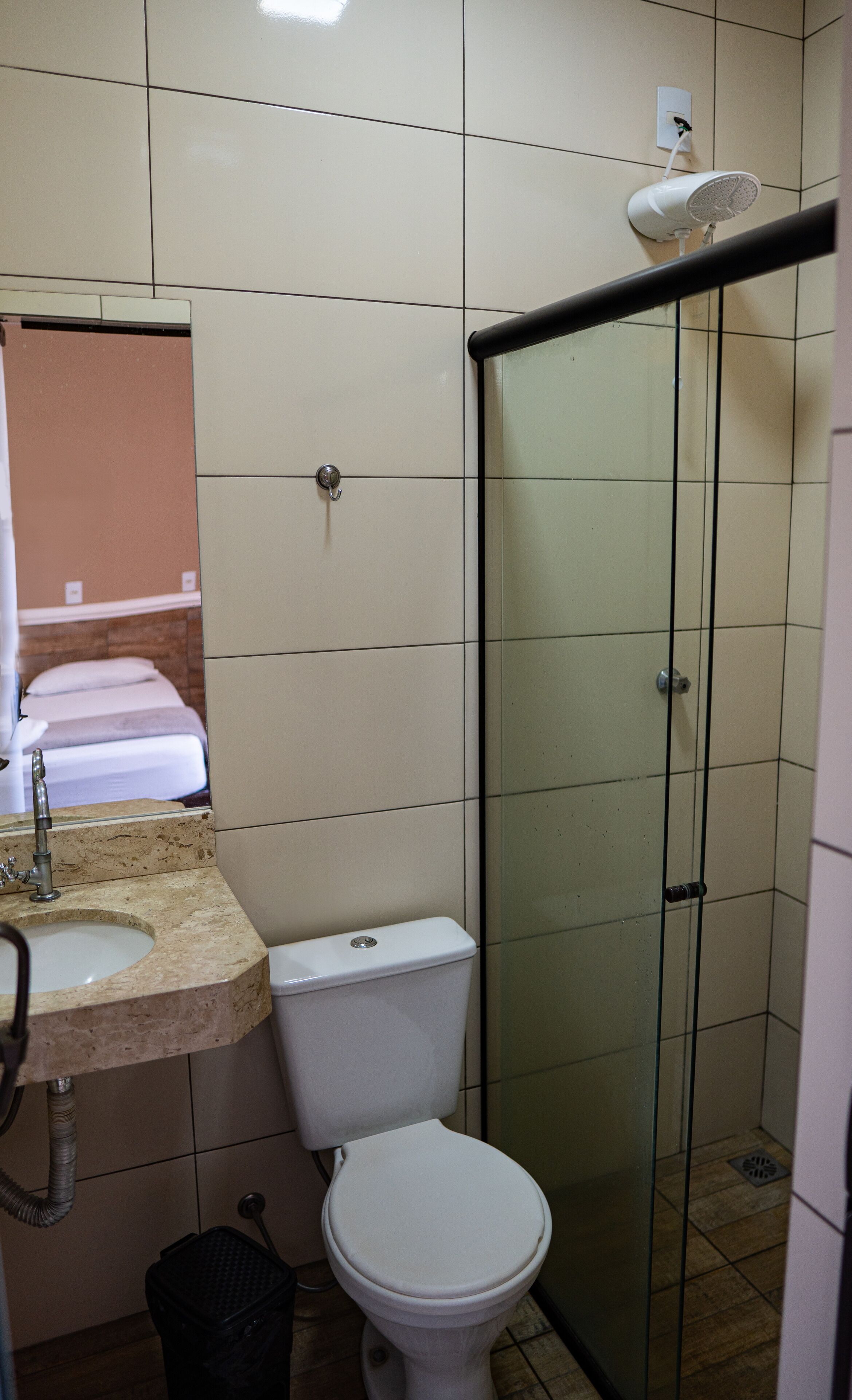 Une salle de bain avec des toilettes, un lavabo et une douche.