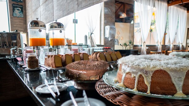 A breakfast buffet with various cakes and a coffee station. - Hotel Nixon (Itai)