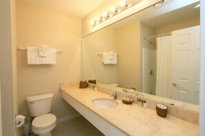 Une salle de bain avec des toilettes, un lavabo et un miroir.