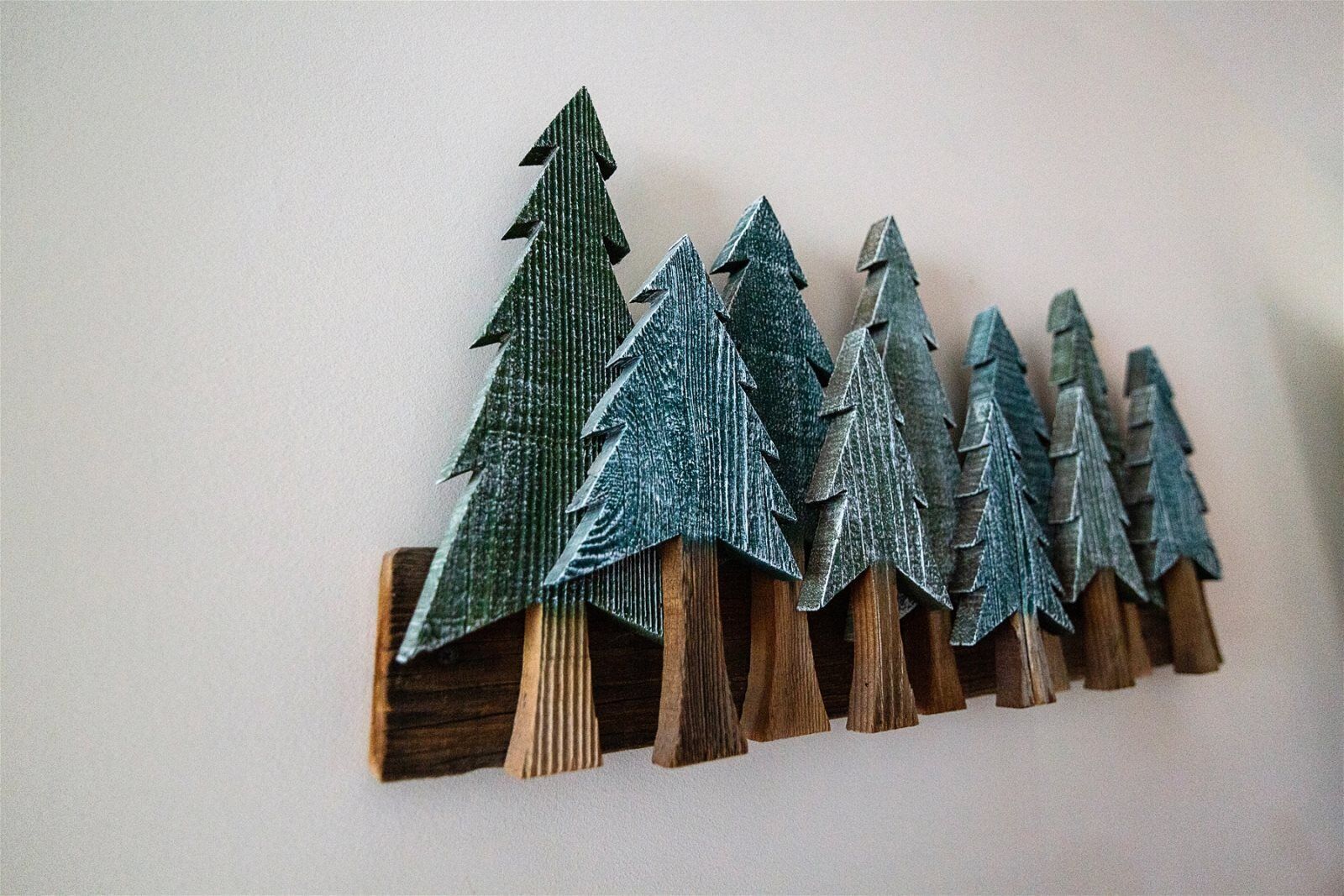 Una hilera de árboles de Navidad de madera con acabado verde texturizado.
