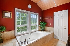 A bathroom with a large bathtub, two windows, a door, and a potted plant. - 3 Bears at Topnotch Resort & Spa (Stowe)