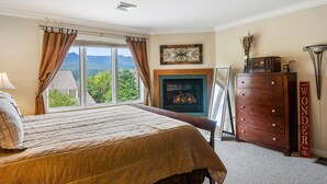 A bedroom with a large bed, a fireplace, a dresser, and a view of the outdoors. - 3 Bears at Topnotch Resort & Spa (Stowe)