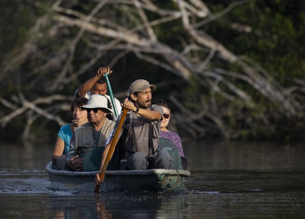 A group of people in a boat on a river.