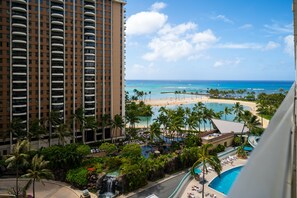 A resort with a pool, palm trees, and a beach view.