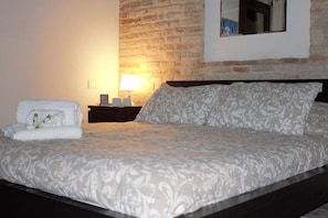 A neatly made bed with a patterned bedspread, a bedside lamp, and a towel on the side. - B&B Casa Fanny (Loreto)