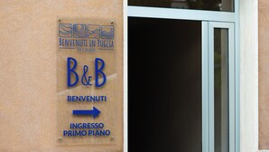 Une enseigne indiquant l’entrée du premier étage pour le B&B Benvenuti in Puglia.