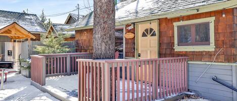 A wooden cabin with a porch, a door labeled "Sunset," and a window.