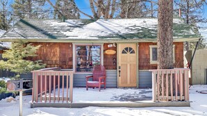 A wooden cabin with a porch, a red chair, and a mailbox. - Sunset #101 (Big Bear Lake)