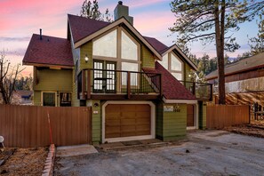 A two-story house with a large garage, a balcony, and a fenced yard. - Fawnskin Chalet#1826 (Fawnskin)
