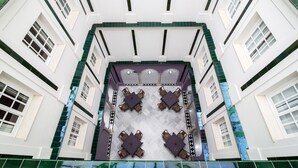 Eine Hotelhalle mit einer zentralen Sitzecke und einer hohen Decke.