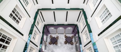 Un vestíbulo de hotel con zona de estar central y techo alto.