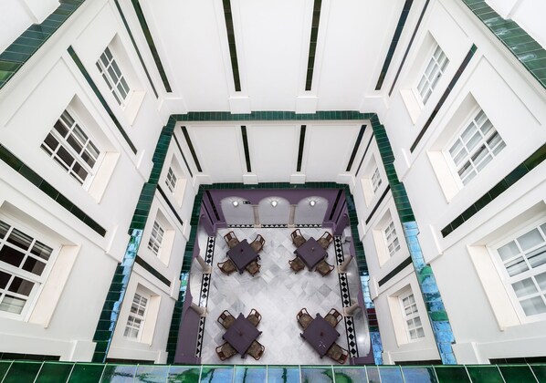 A hotel lobby with a central seating area and a high ceiling.