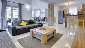 A modern living room with a sofa, coffee table, and dining area. - Villa with private pool, 4 bikes just 590 meters to the pebble beach (Valbandon)