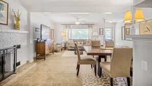A spacious living room with a fireplace, a dining area, and a kitchen. - Azure 2- Lakefront w/ Shared Pool & Dog Friendly (Kingsland)