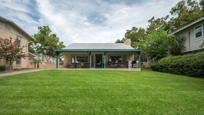 A covered patio area with outdoor seating, a lawn, and a house in the background. - Azure 2- Lakefront w/ Shared Pool & Dog Friendly (Kingsland)