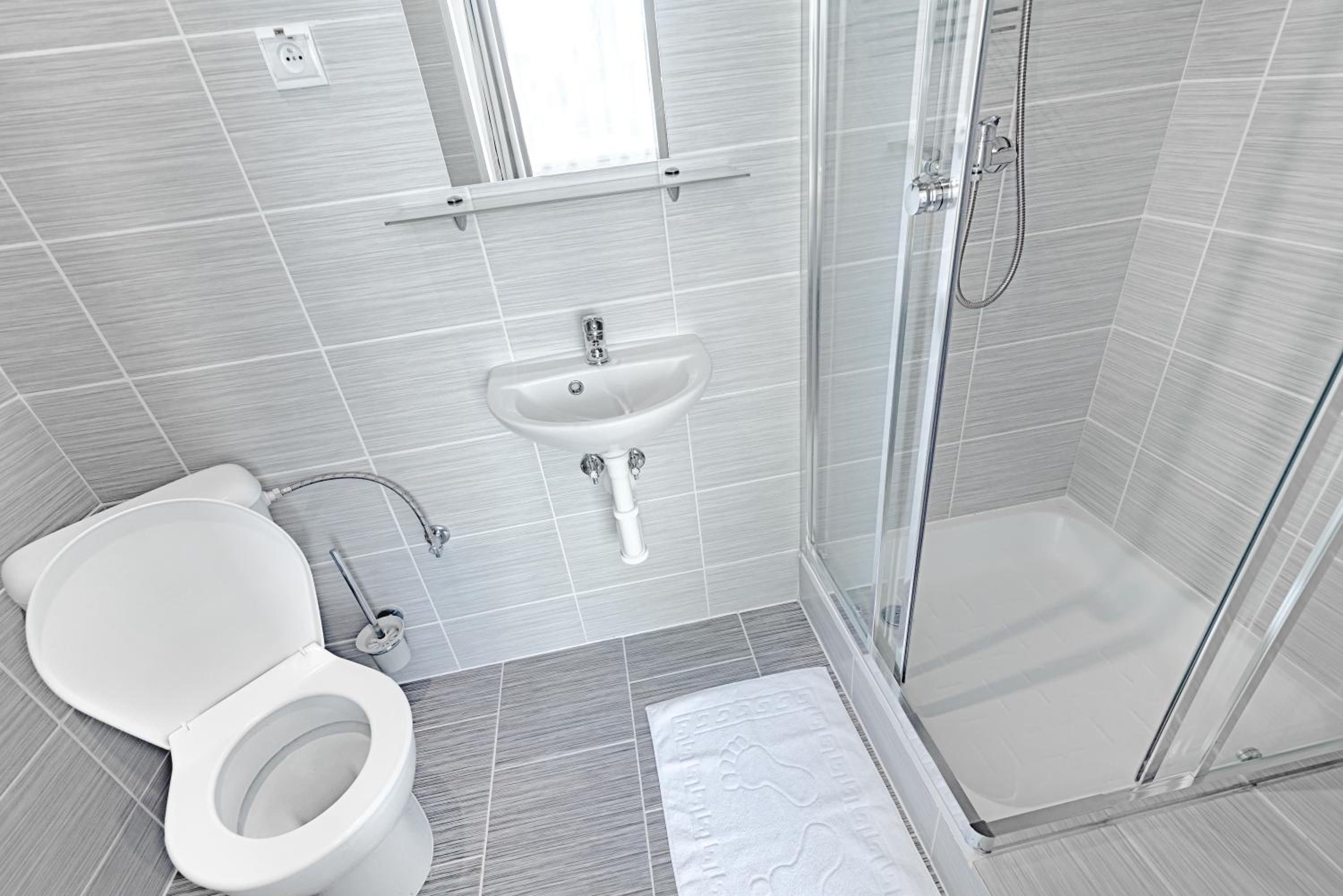 Une salle de bain moderne équipée de toilettes, d’un lavabo et d’une douche.