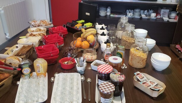 A buffet table with various food items and condiments. - Enzo Hotels Contrexéville (Contrexéville)