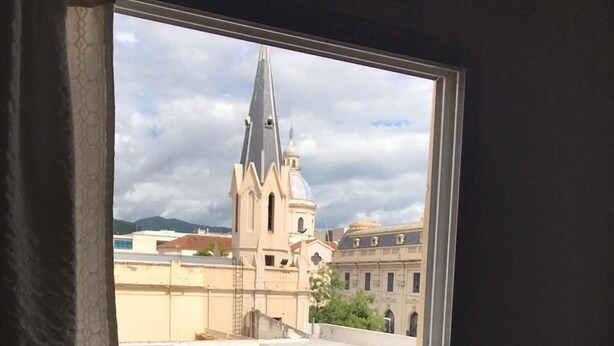 Una ventana con vista a una iglesia y edificios circundantes.