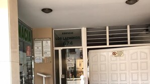 Entrada de un edificio con un cartel que dice 'Edificio Los Lapachos 674'.