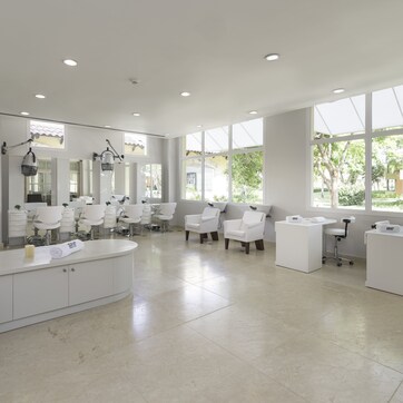 A modern spa with a large reception area, multiple seating options, and large windows providing natural light.