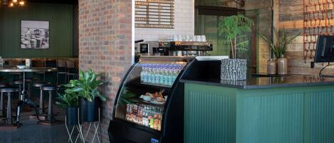A coffee shop interior with a counter, seating area, and a menu board.