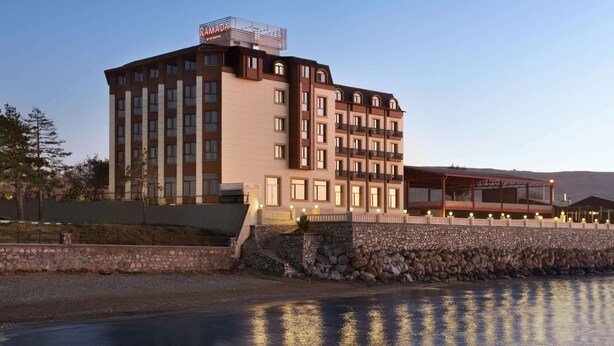 A multi-story hotel with a stone facade, balconies, and a rooftop terrace. - Ramada by Wyndham Van (Edremit)