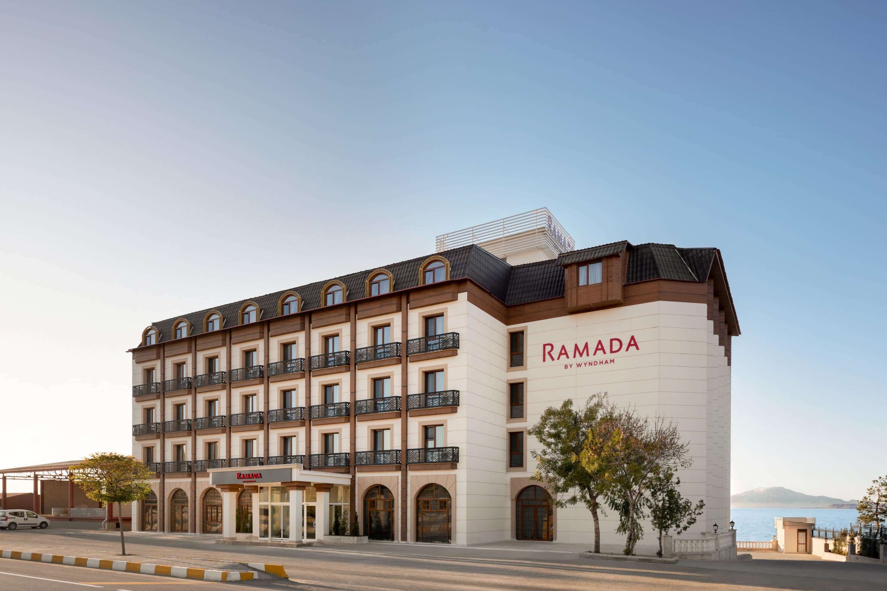 Un hotel de varios pisos con balcones y vista al mar.