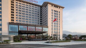 Een meerhoog hotel met een opvallend bord waarop 'RAMADA PLAZA BY WYNDHAM' staat.