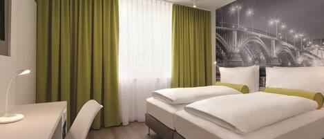 A hotel room with two beds, a desk, and a chair.