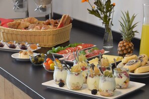 A buffet with various food items including pastries, fruits, and a pineapple. - Lizz Hotel Munich (Munich)