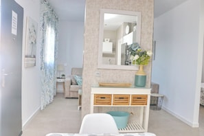 A modern living room with a sofa, a coffee table, and a TV. There is a dining table with chairs and a kitchen area in the background. - Fabulous holiday home with private pool (Conil de la Frontera)