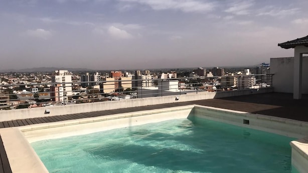 Una piscina en la azotea con vistas a un paisaje urbano.