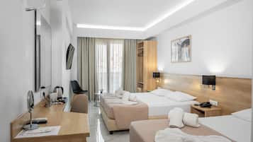 Habitación de hotel con dos camas, un escritorio con computadora, una silla, un televisor y una ventana con cortinas.