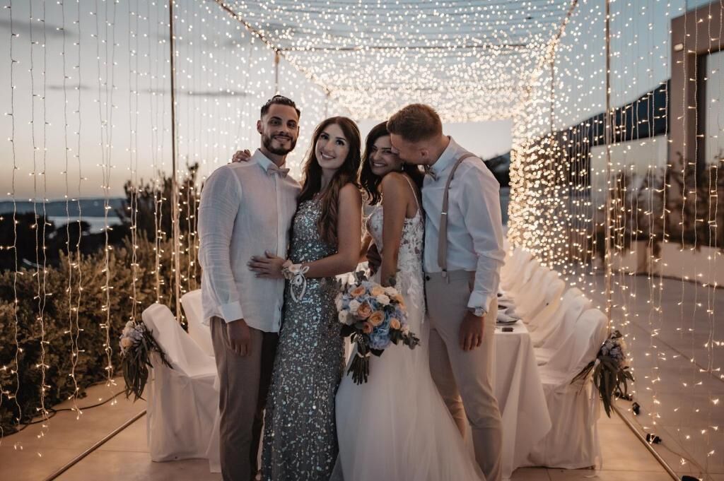 Una ceremonia de boda con invitados debajo de luces colgantes.