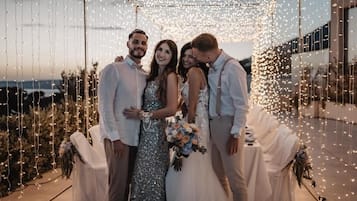 Una ceremonia de boda con invitados debajo de luces colgantes.