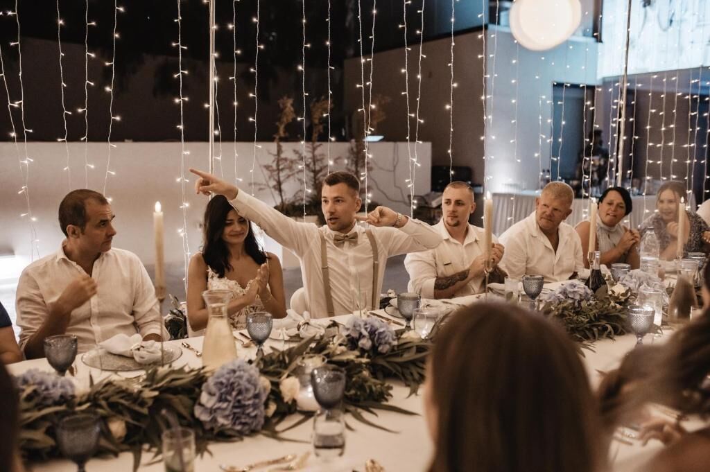 Een eettafel gedekt met kaarsen, glazen en bloemdecoraties.