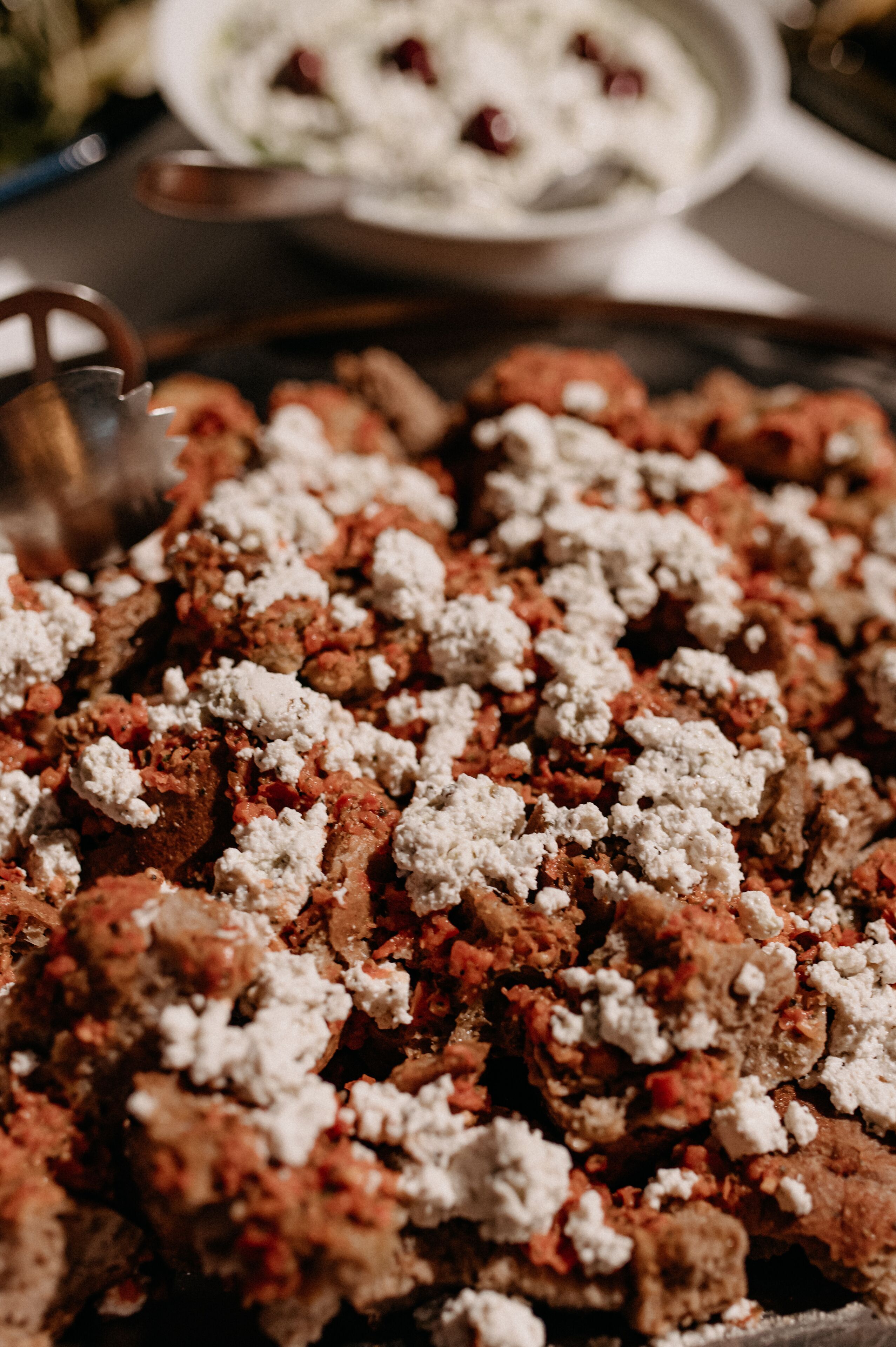 A close-up of a food dish with crumbled cheese and meat.