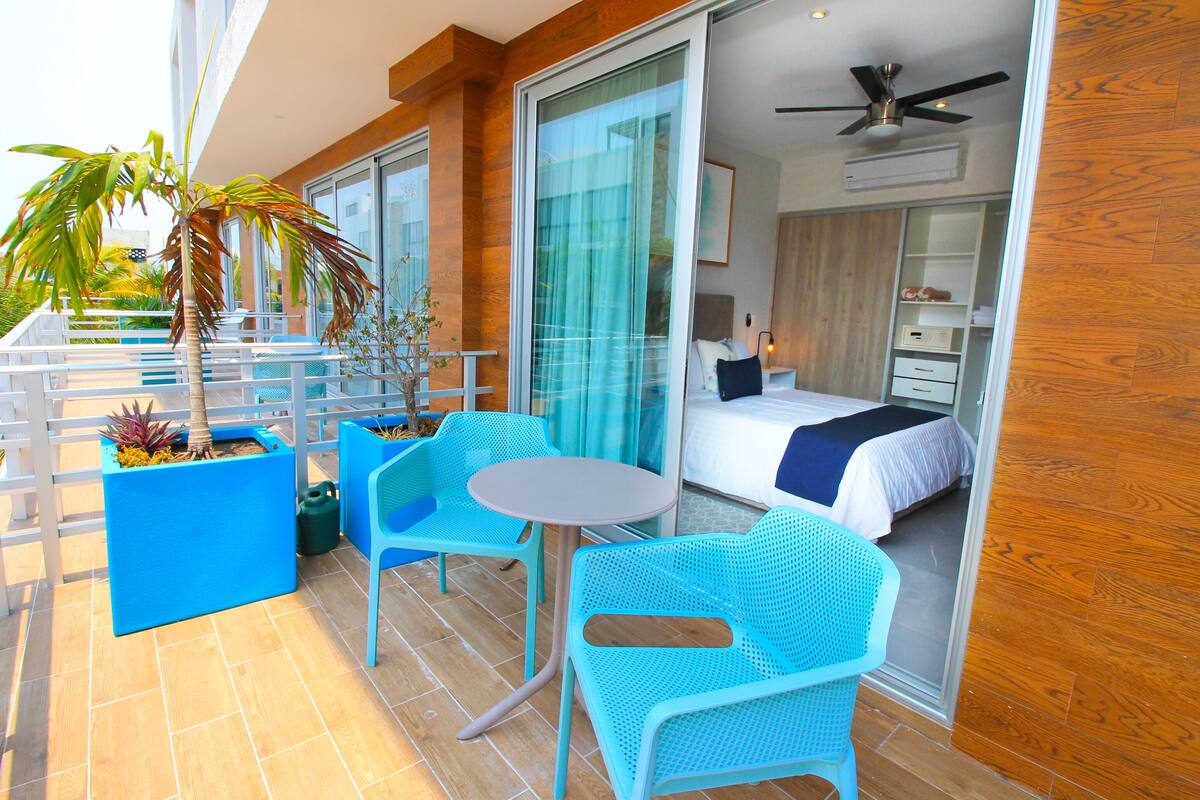 A balcony with a bed, a ceiling fan, and a view of the ocean.