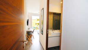 A modern bathroom with a large mirror, a sink, and a shower. - The Gallery Apartments (Playa del Carmen)