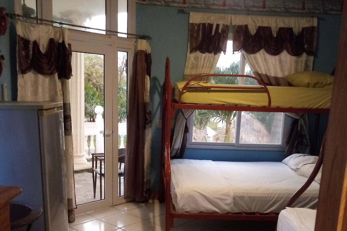 Una habitación con una litera, un escritorio y un refrigerador.