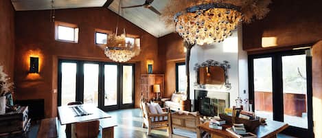 A spacious living area with a large wooden table, comfortable seating, and a fireplace.