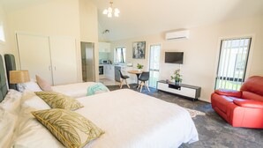Un dormitorio con cama, escritorio, silla y televisor.