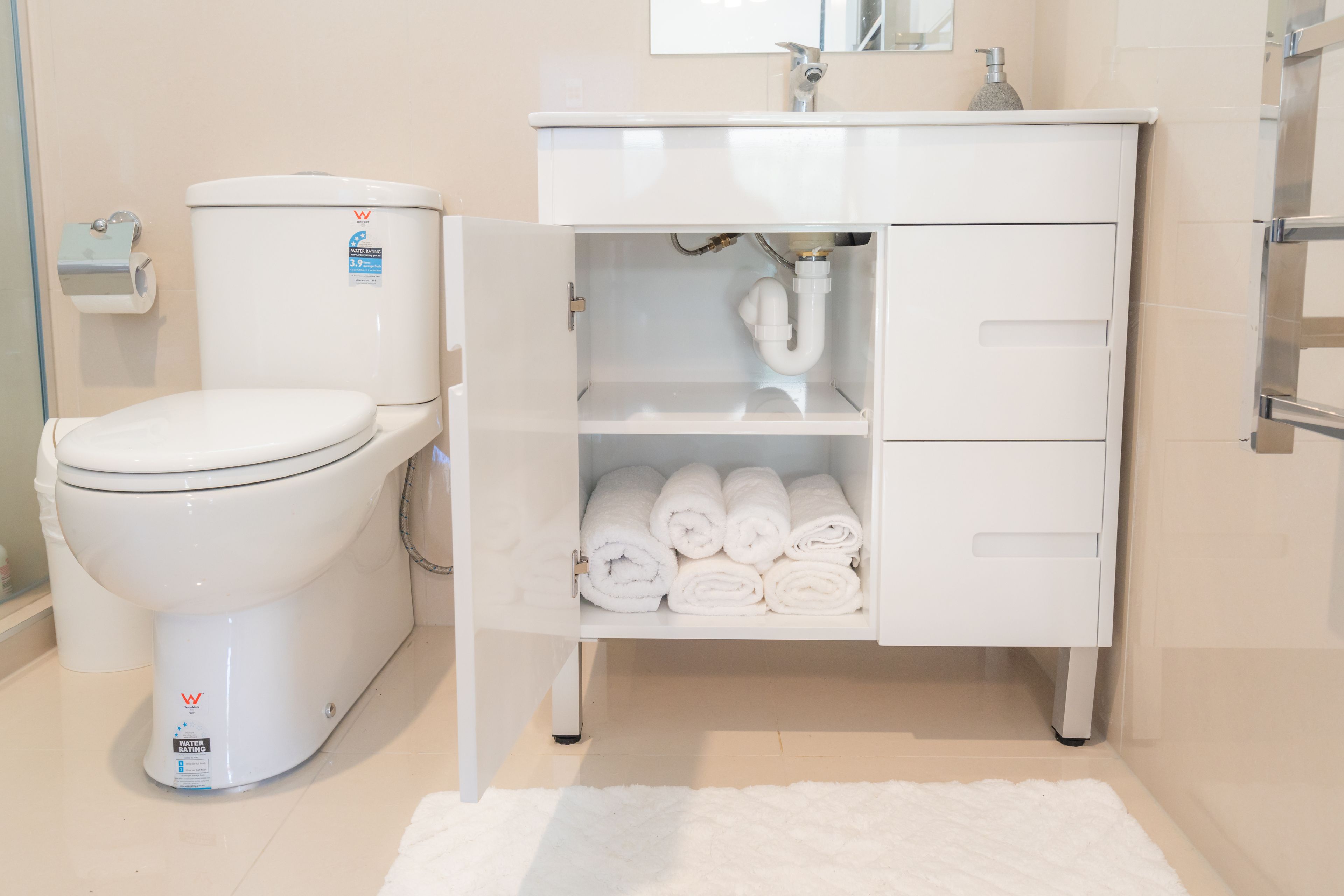 Un baño con inodoro, lavabo y toallero.