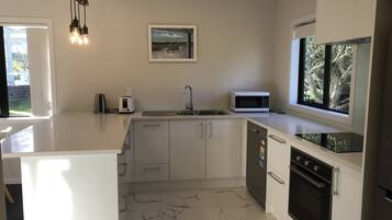 A modern kitchen with a marble floor, a sink, a microwave, and a dishwasher.