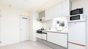 Una cocina moderna con gabinetes blancos, microondas, lavavajillas y estufa.