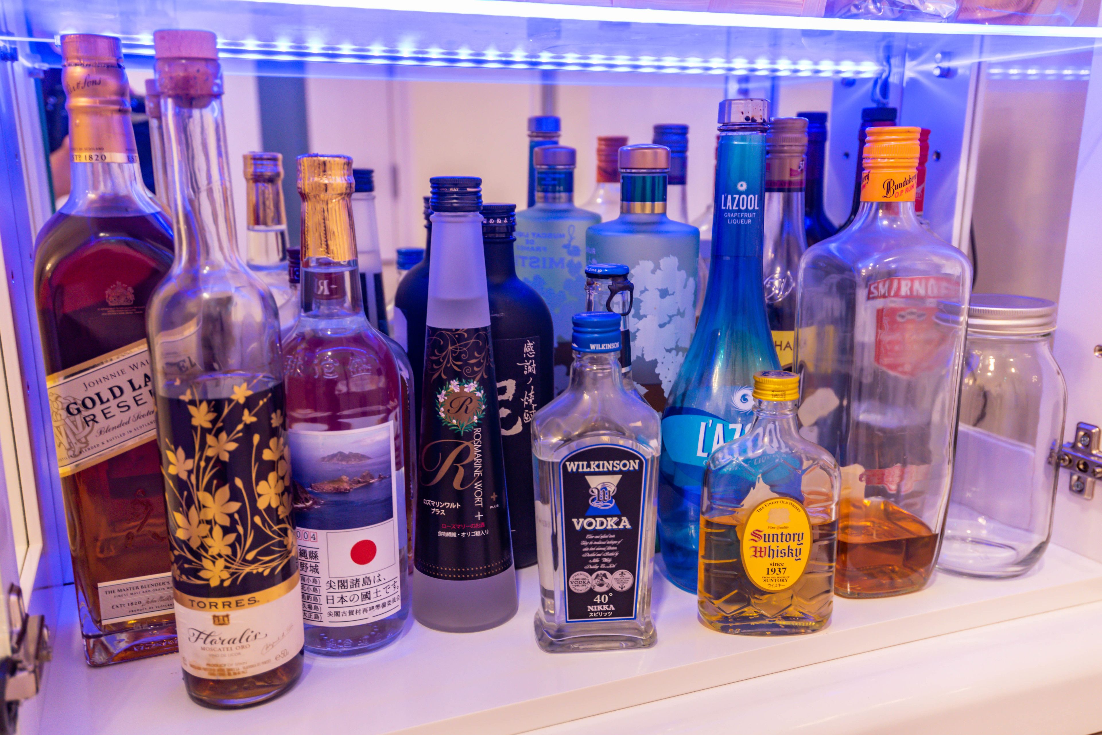 A collection of liquor bottles in a refrigerated display.