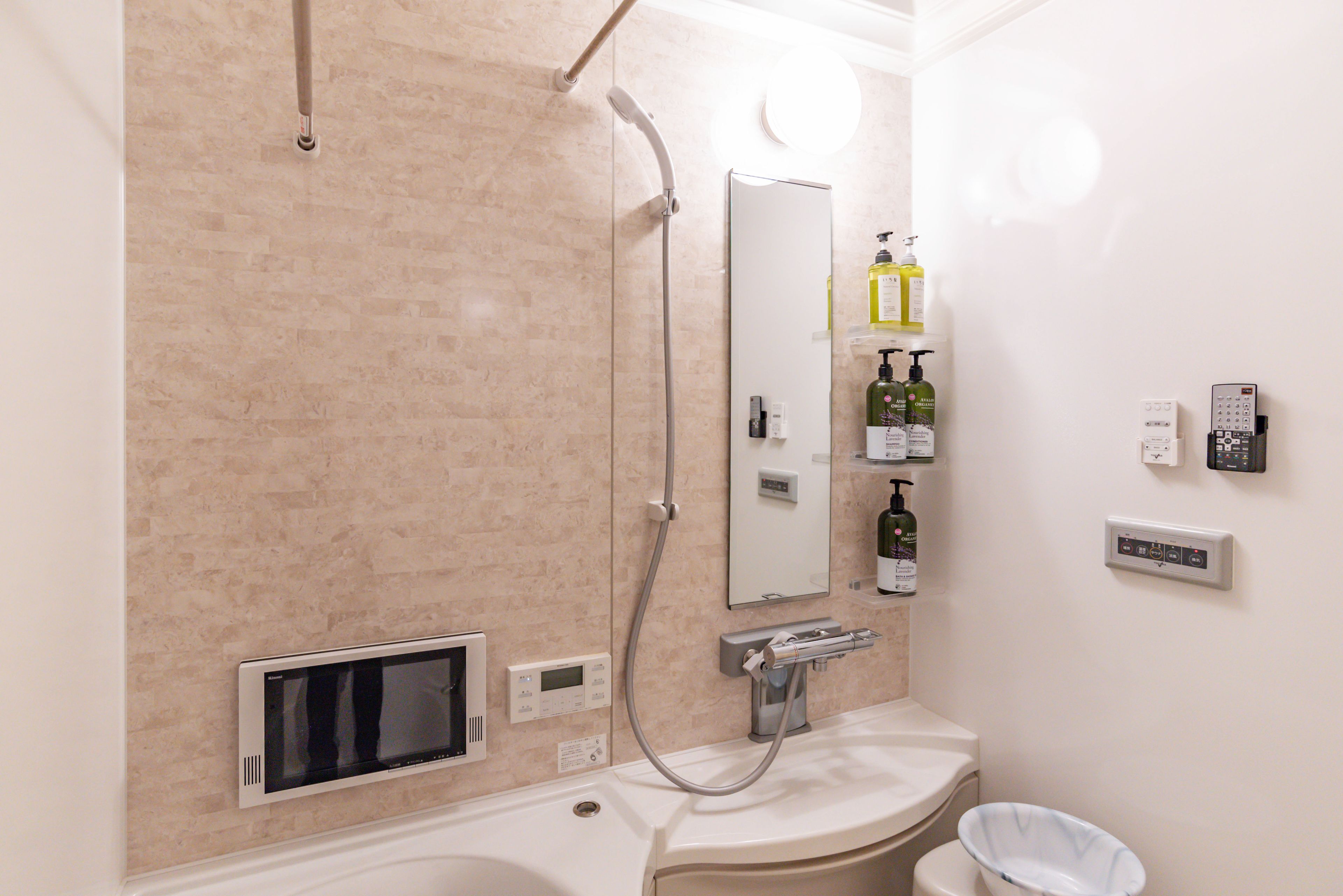 Une salle de bain équipée d’une douche, d’un lavabo, d’un miroir et de toilettes.