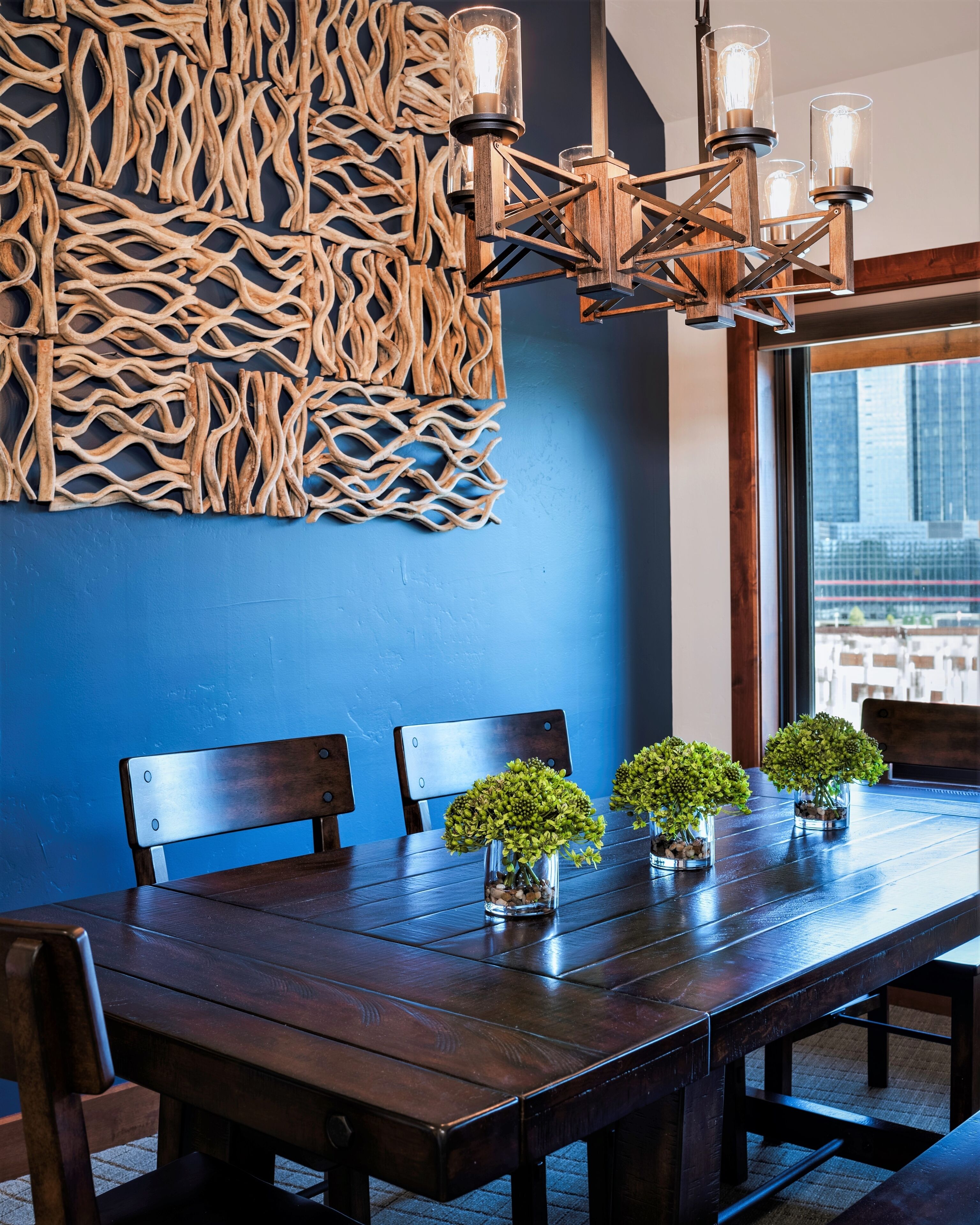 A dining area with a wooden table, chairs, and a decorative wall with a woven pattern.